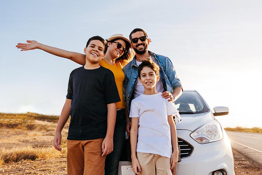 Client Center - Young Family Standing in Front of Their White Car on a Long Country Lane