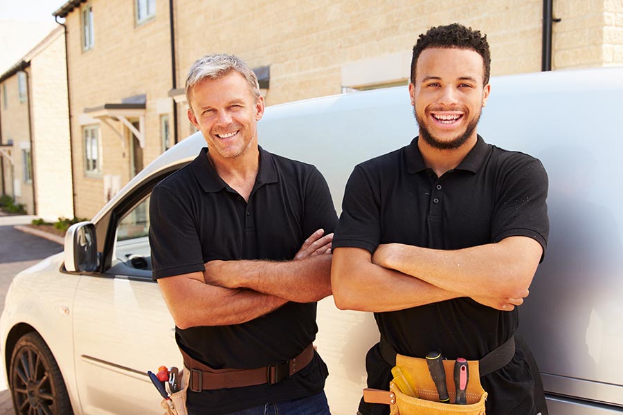 Business Insurance - Contractors Stand by Their Work Van on a Residential Street, Both Smiling